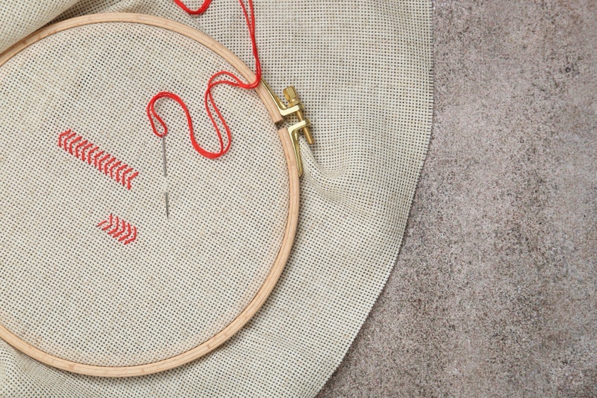 Close-up of embroidery hoop with red thread stitching